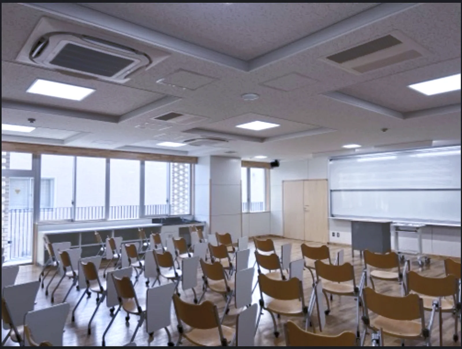 葛飾区立道上小学校の室内にある机と椅子、天井の空調機